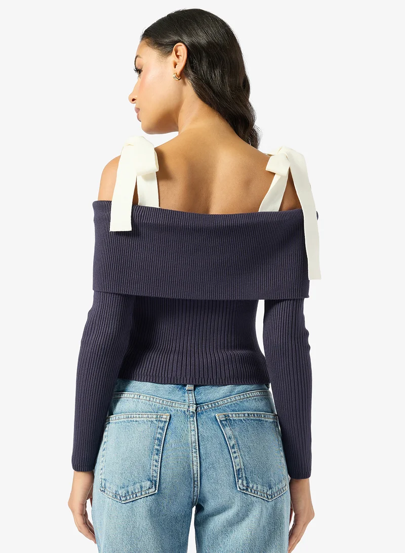 جس كنزة بكتف مكشوف وأكمام طويلة